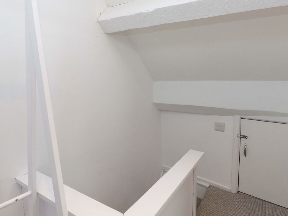 A hallway with stairs and a door at Bodefi in Pwllheli