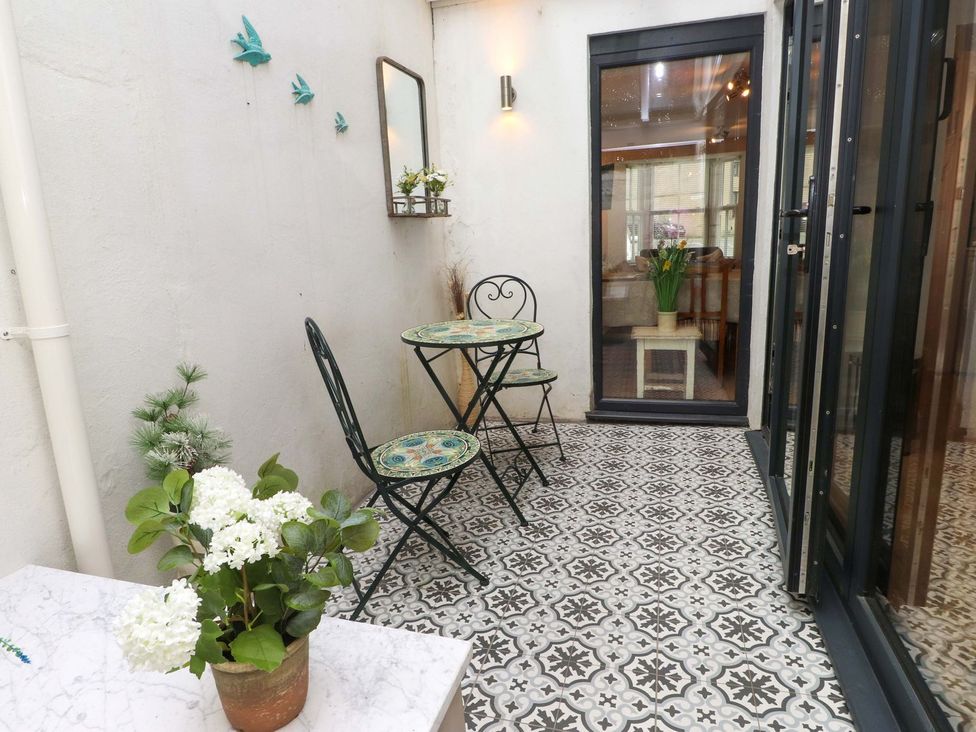 A patio with a table and chairs at Bodefi in Pwllheli
