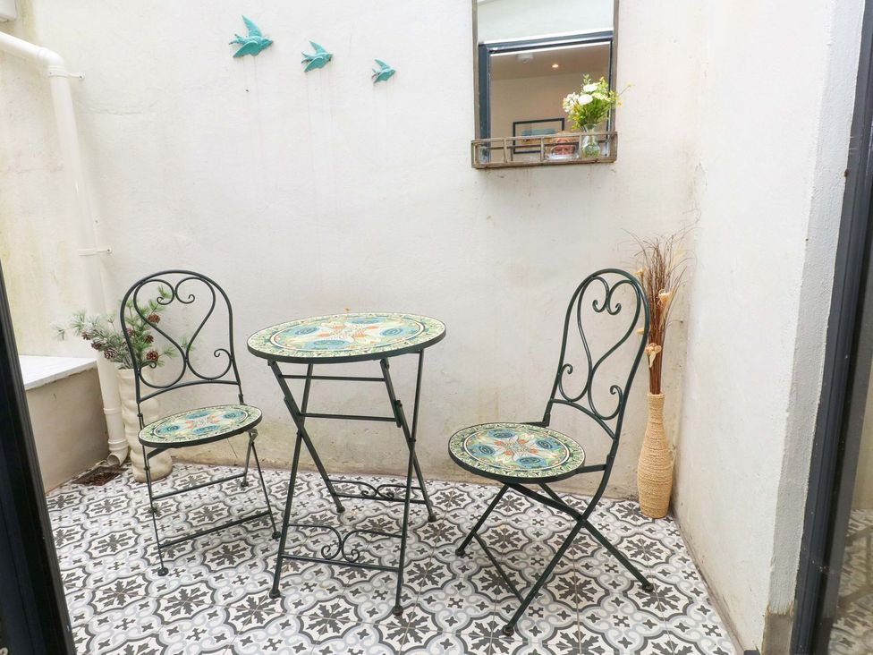 A patio with a table and chairs at Bodefi in Pwllheli