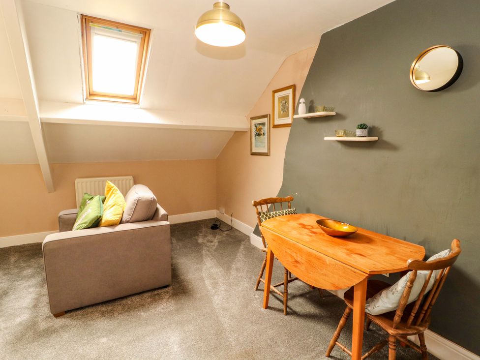 A living room with a sofa and dining table at The Loft Apartment @ The Stag Inn Maryport