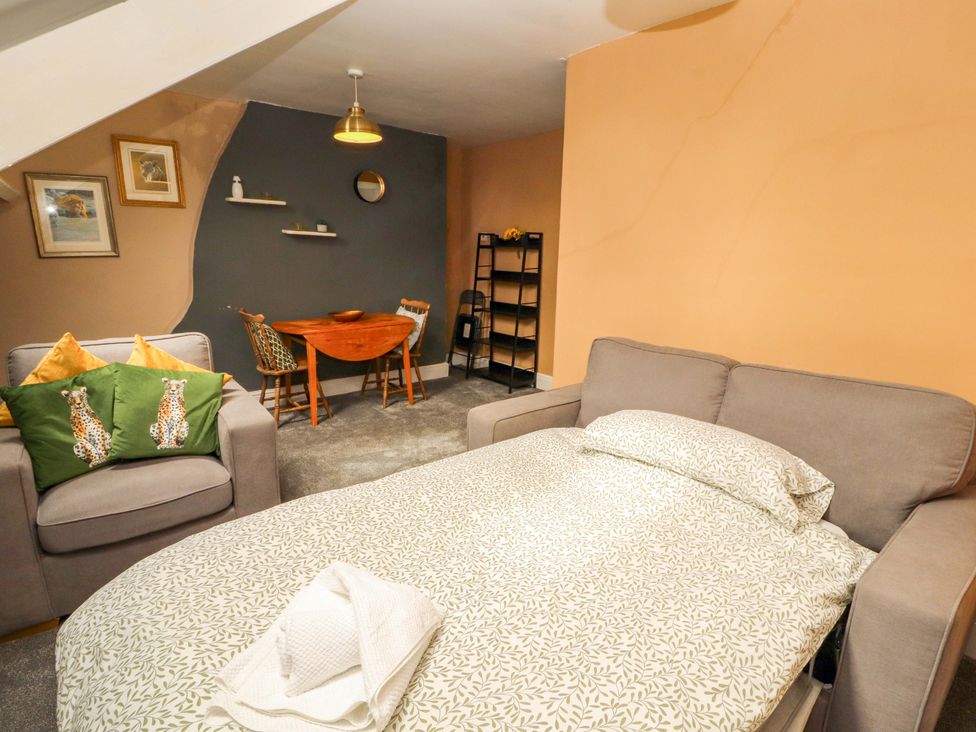 A living room with a sofa bed and dining table at The Loft Apartment @ The Stag Inn Maryport