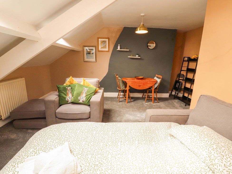 A studio apartment with a bed and dining area at The Loft Apartment @ The Stag Inn Maryport