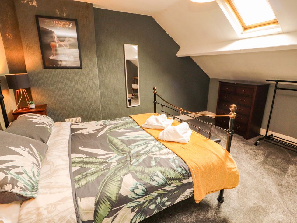 A bedroom with a bed and a chest of drawers at The Loft Apartment @ The Stag Inn, Maryport