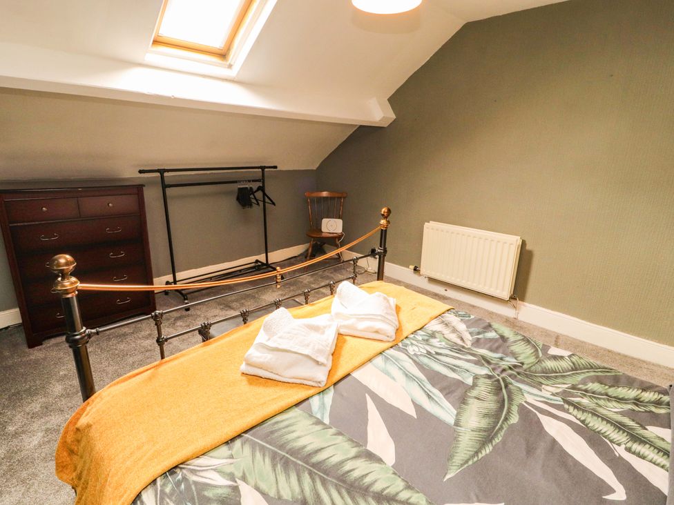 A bedroom with a bed and a chest of drawers at The Loft Apartment @ The Stag Inn Maryport
