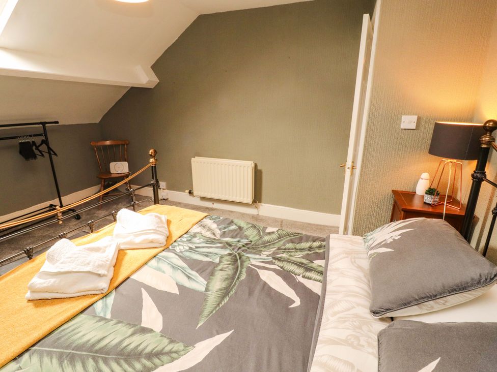 A bedroom with a bed and wardrobe rack at The Loft Apartment @ The Stag Inn in Maryport