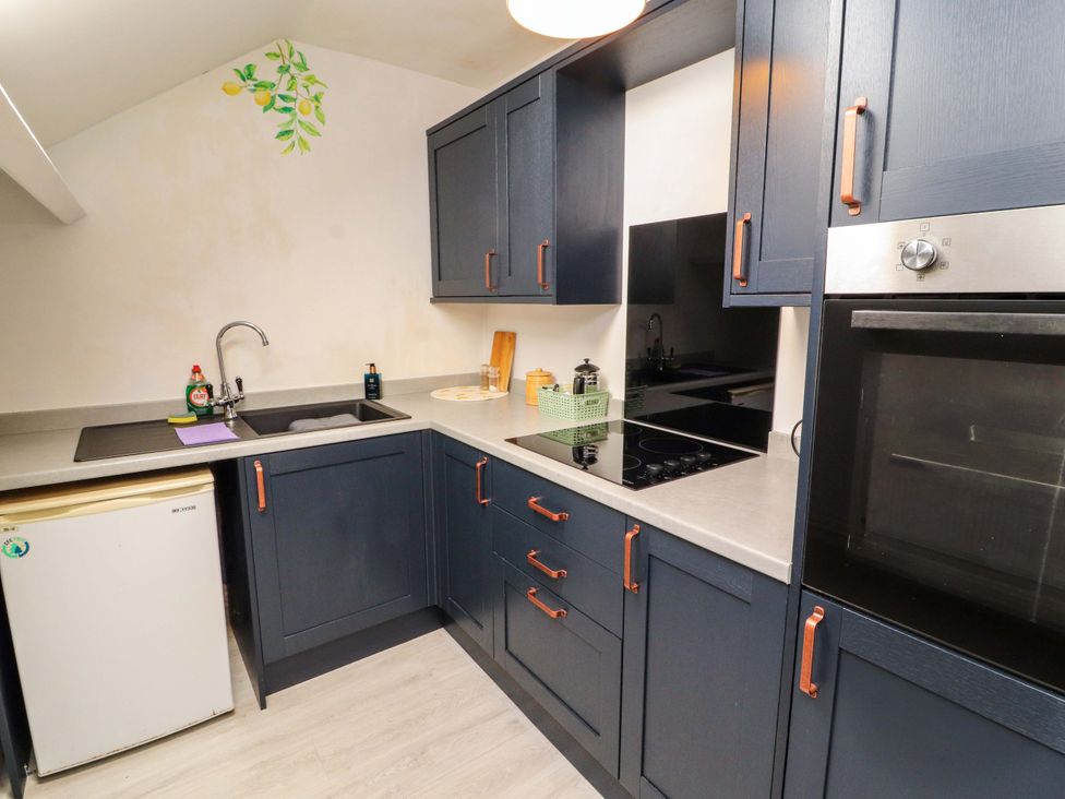 A kitchen with a sink and cooking appliances at The Loft Apartment @ The Stag Inn, Maryport