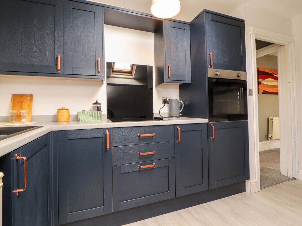 Kitchen with dark cabinets and appliances at The Loft Apartment @ The Stag Inn Maryport