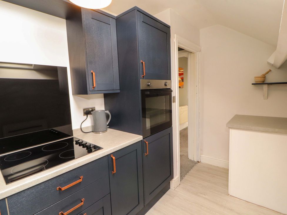 A kitchen with cabinets and appliances at The Loft Apartment @ The Stag Inn, Maryport