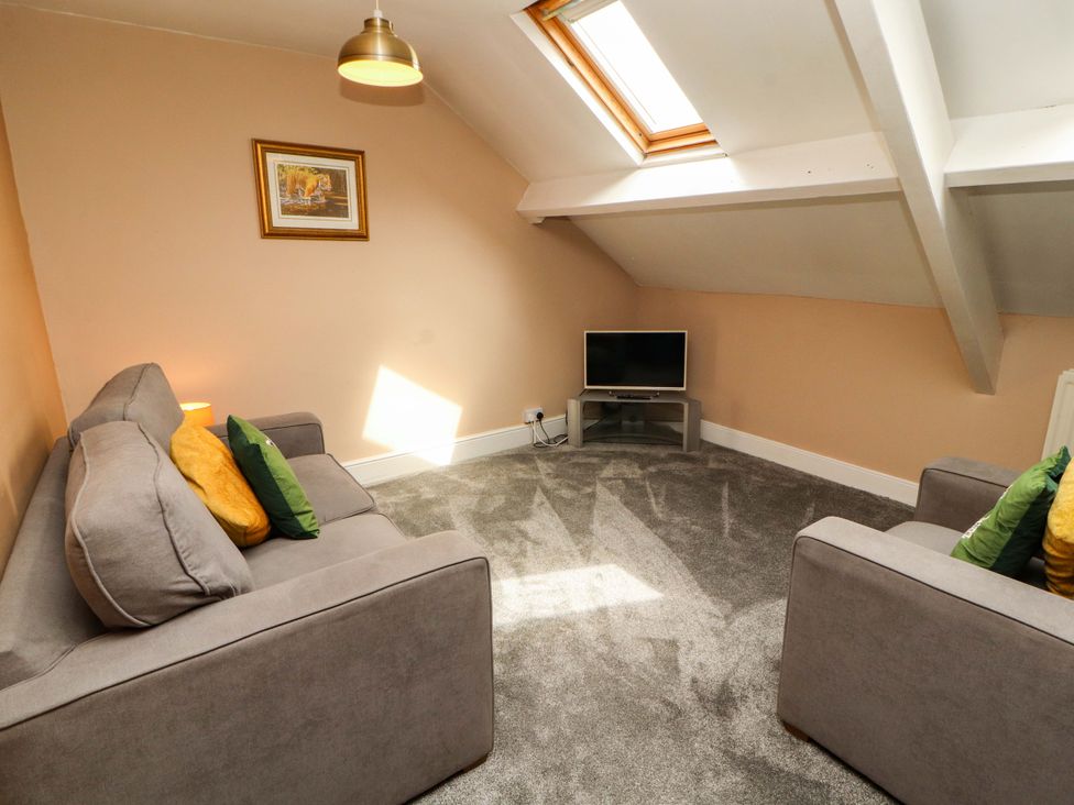 A living room with sofas and a television at The Loft Apartment @ The Stag Inn Maryport