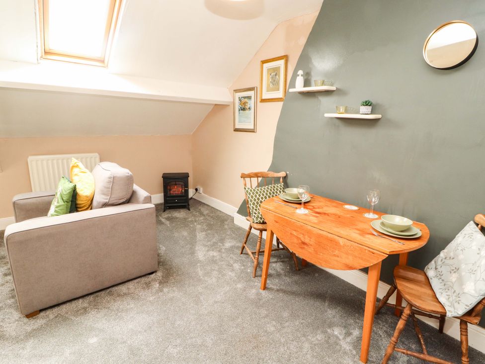 A living room with a sofa and dining table at The Loft Apartment @ The Stag Inn, Maryport