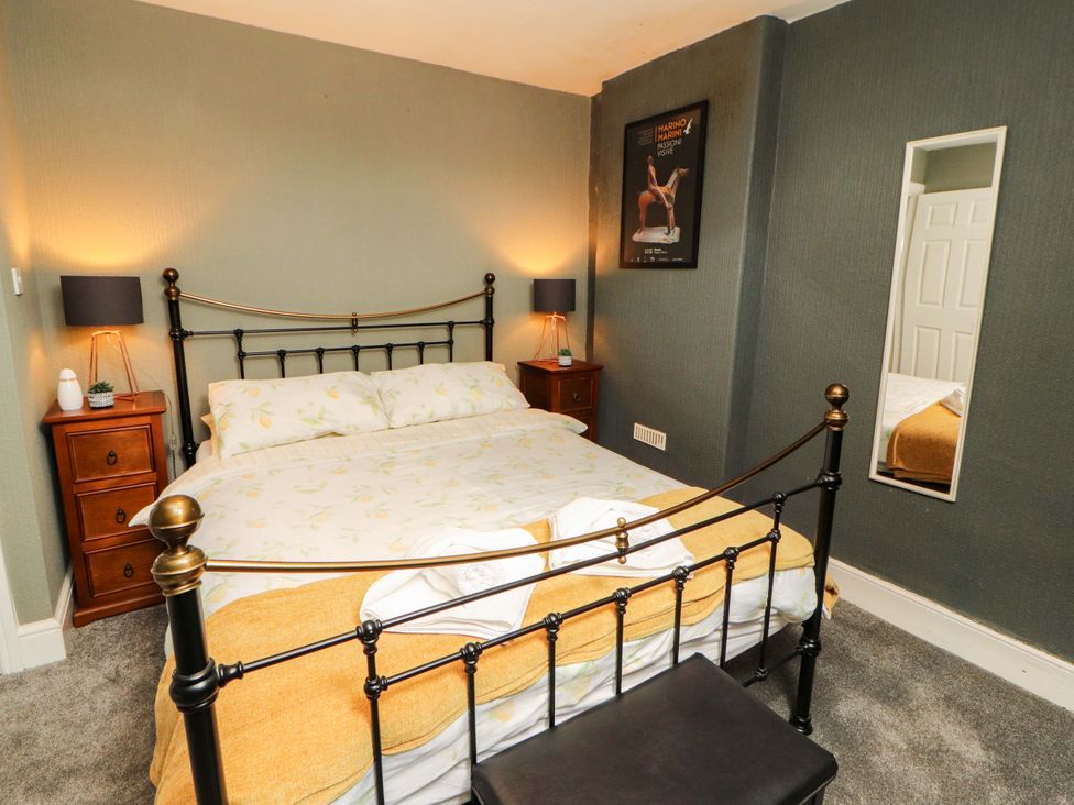 A bedroom with a bed and two bedside tables at The Loft Apartment @ The Stag Inn, Maryport