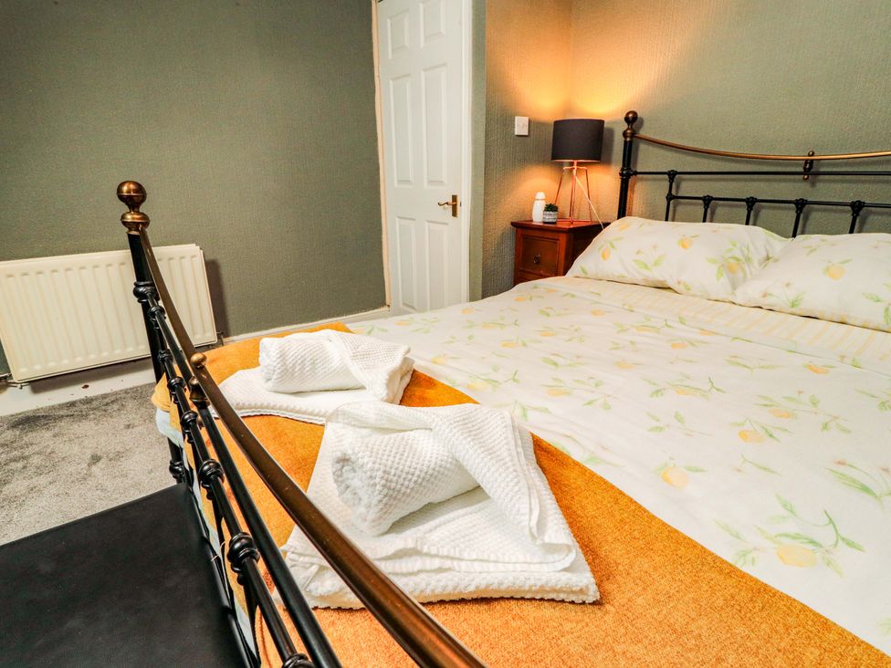 A bedroom with a bed and bedside table at The Loft Apartment @ The Stag Inn Maryport