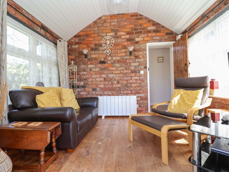 A snug with a sofa and armchair at Ty Haf in Rhosemor