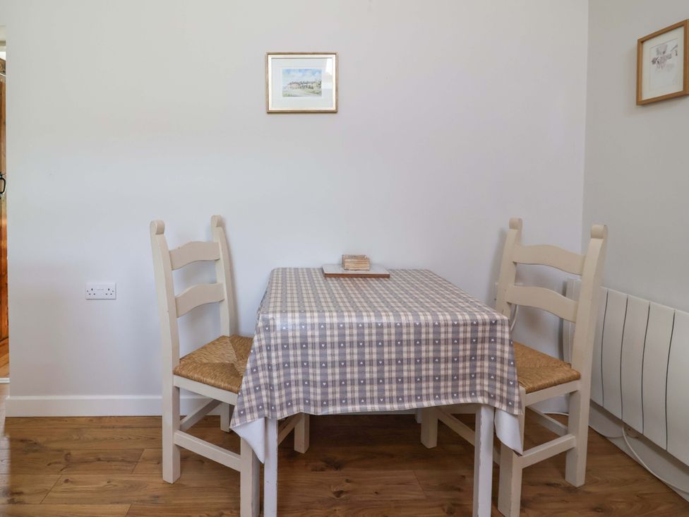 A dining room with a table and chairs at Ty Haf in Rhosemor