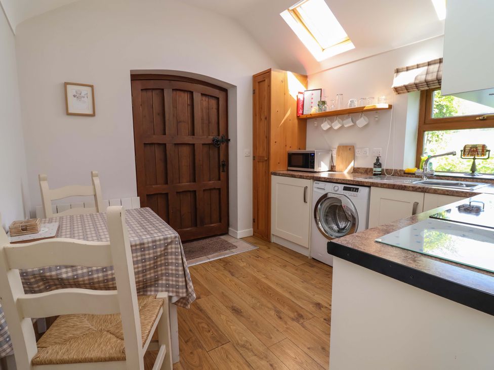 A kitchen with a table and chairs at Ty Haf in Rhosemor