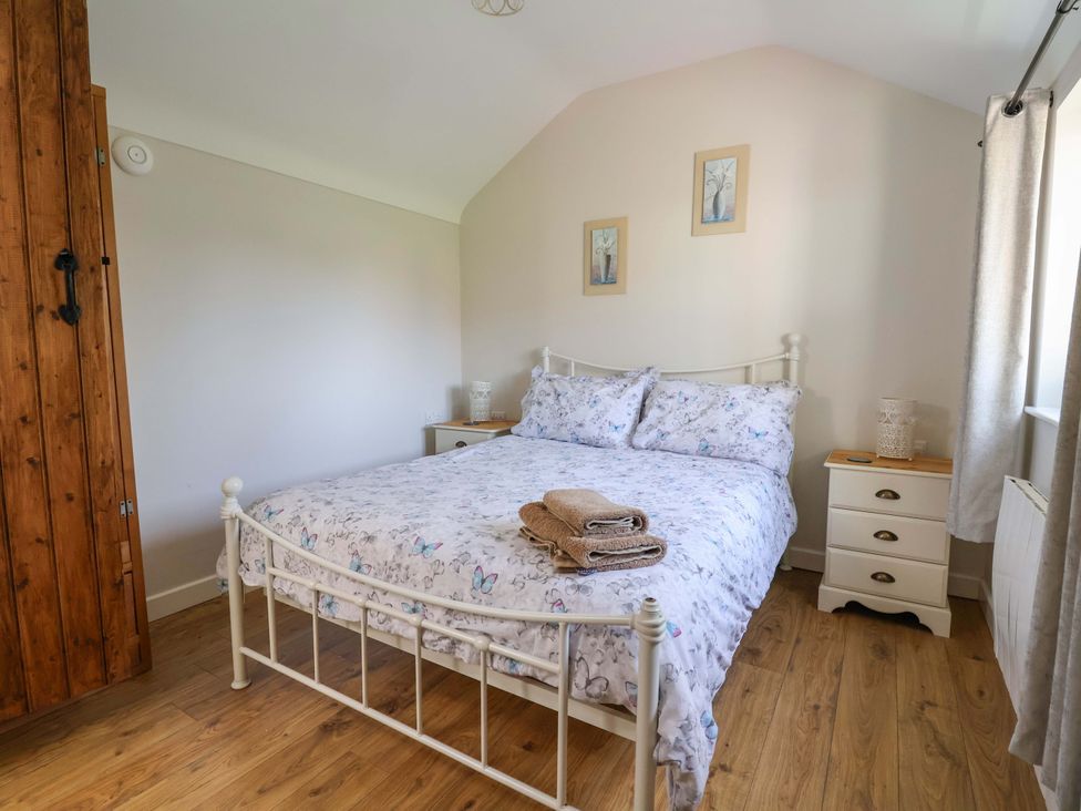A bedroom with a bed and bedside table at Ty Haf in Rhosemor