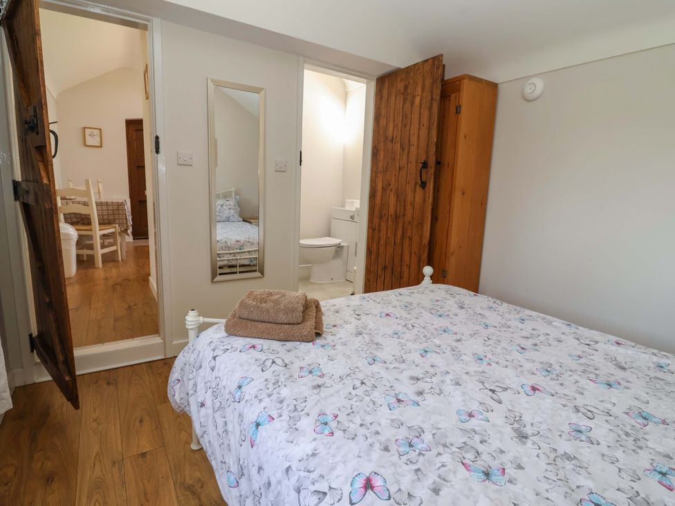 A bedroom with a bed and access to bathroom facilities at Ty Haf in Rhosemor