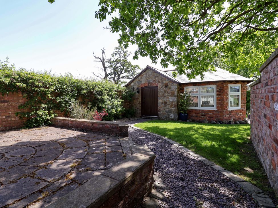 An outdoor area with a pathway leading to a stone building at Ty Haf in Rhosemor