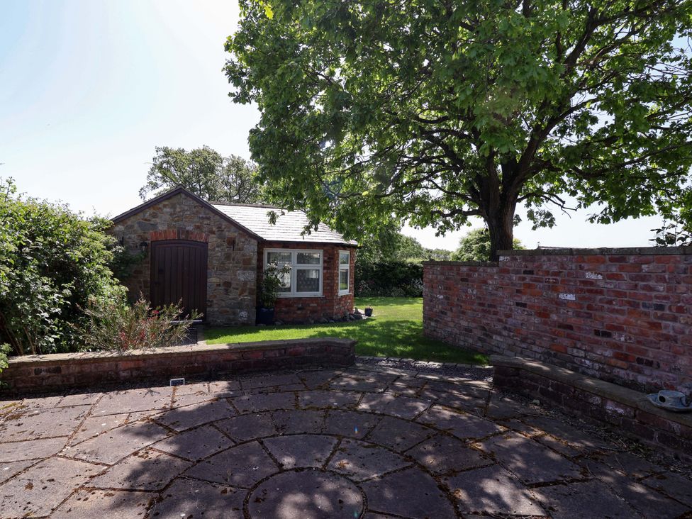 An outdoor area with a stone shed and a tree at Ty Haf in Rhosemor