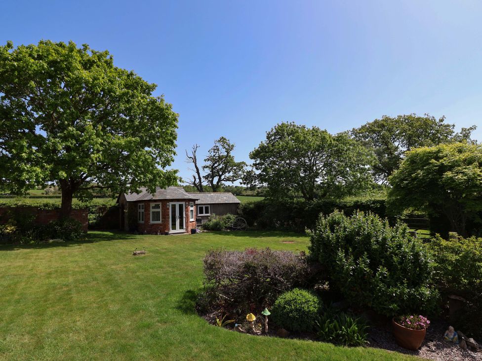 A garden with trees and a shed at Ty Haf in Rhosemor