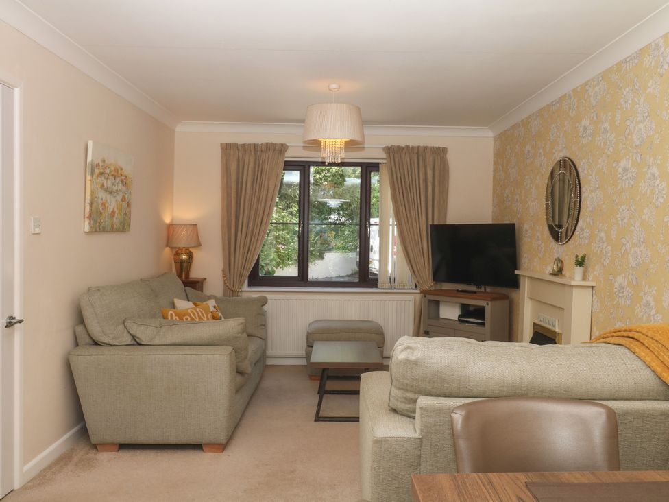 A living room with a sofa and television at Marldon Mews in Marldon