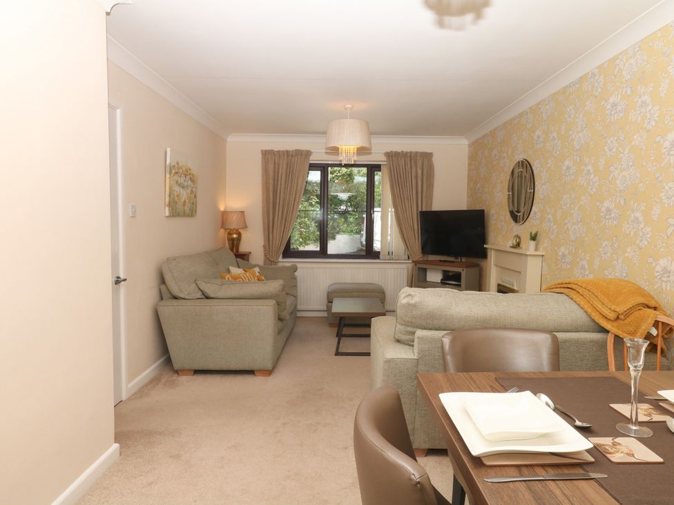 A living room with sofas and a table at Marldon Mews in Marldon