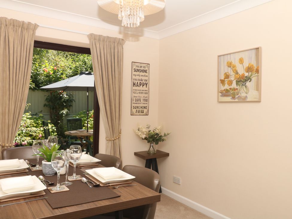 A dining room with a table set and flowers at Marldon Mews in Marldon