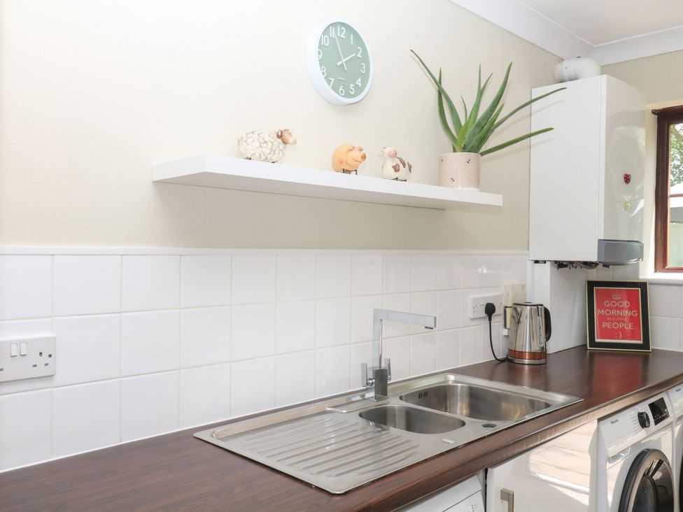 A kitchen with a sink and shelf at Marldon Mews in Marldon