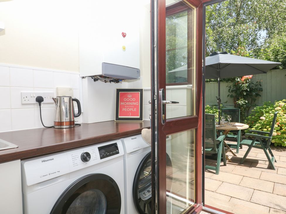A kitchen with a washing machine and kettle at Marldon Mews in Marldon