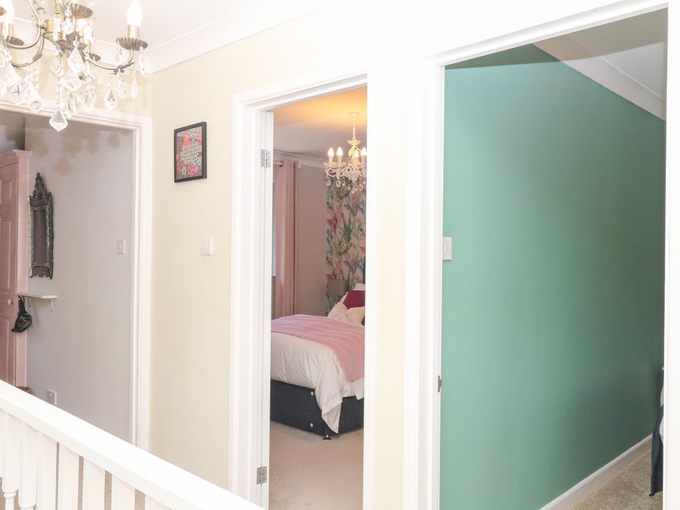 A hallway with chandeliers and doorways at Marldon Mews in Marldon