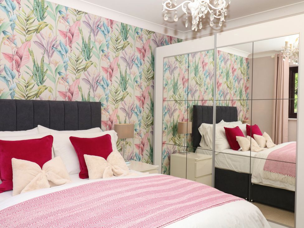 A bedroom with a bed and mirrored wardrobe at Marldon Mews in Marldon