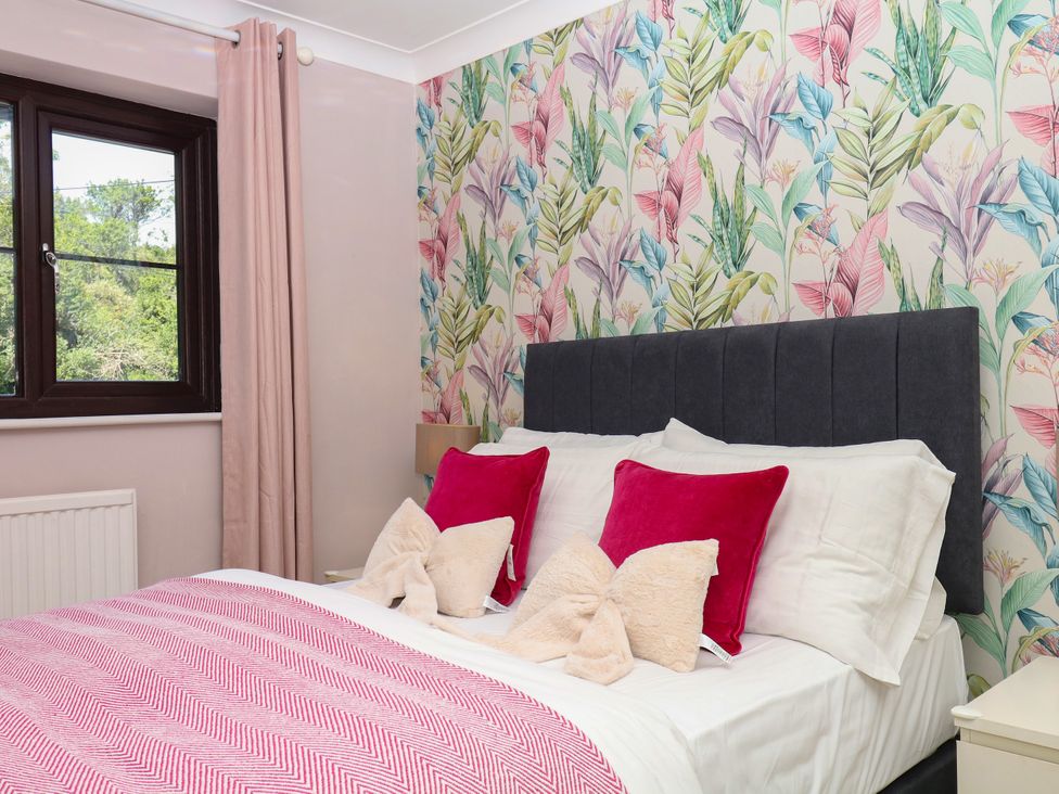 A bedroom with a bed and colorful wall at Marldon Mews in Marldon
