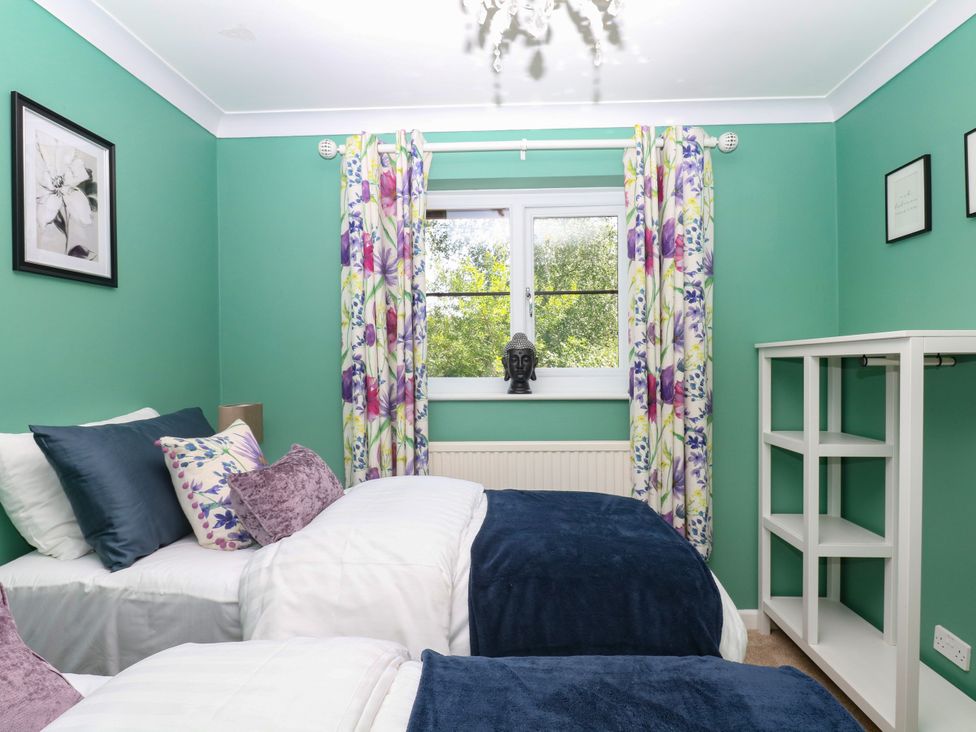 A bedroom with two beds and a shelf at Marldon Mews in Marldon