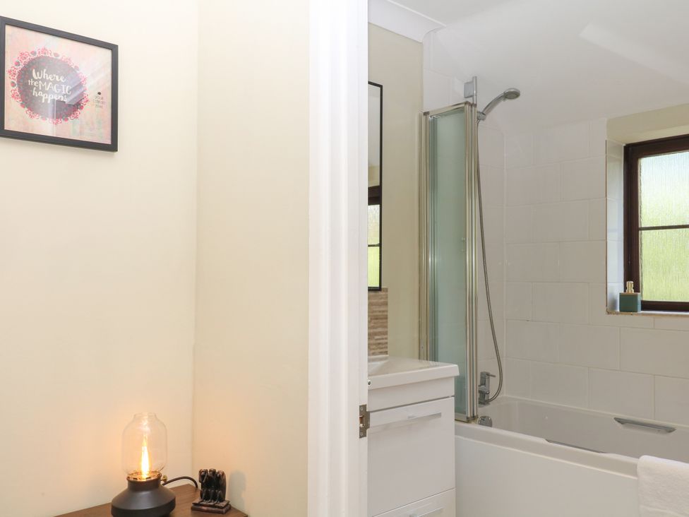 A bathroom with a bathtub, shower, and sink at Marldon Mews in Marldon