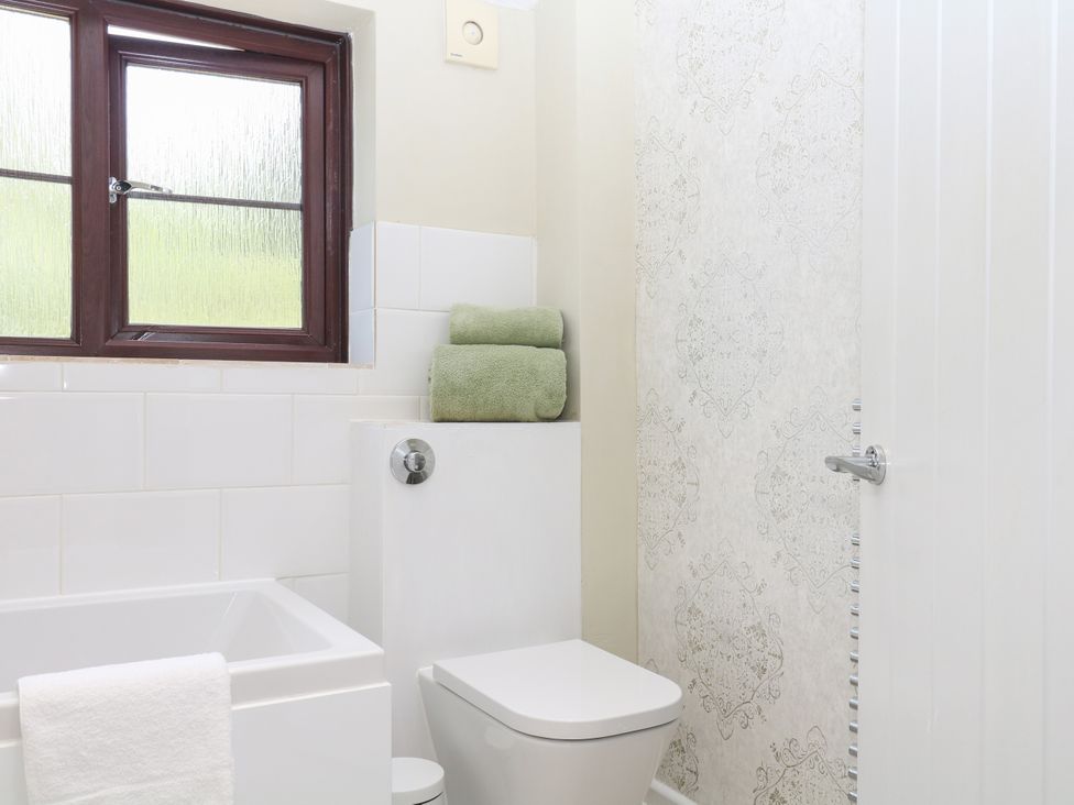 A bathroom with a bathtub and a toilet at Marldon Mews in Marldon