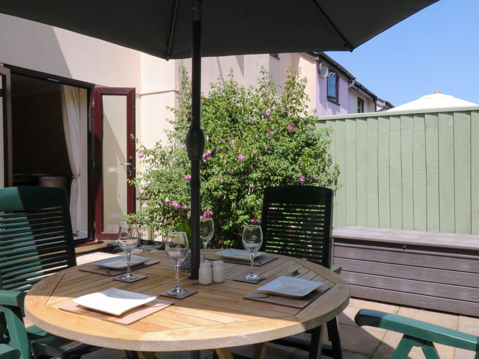 An outdoor patio with a table and chairs at Marldon Mews in Marldon