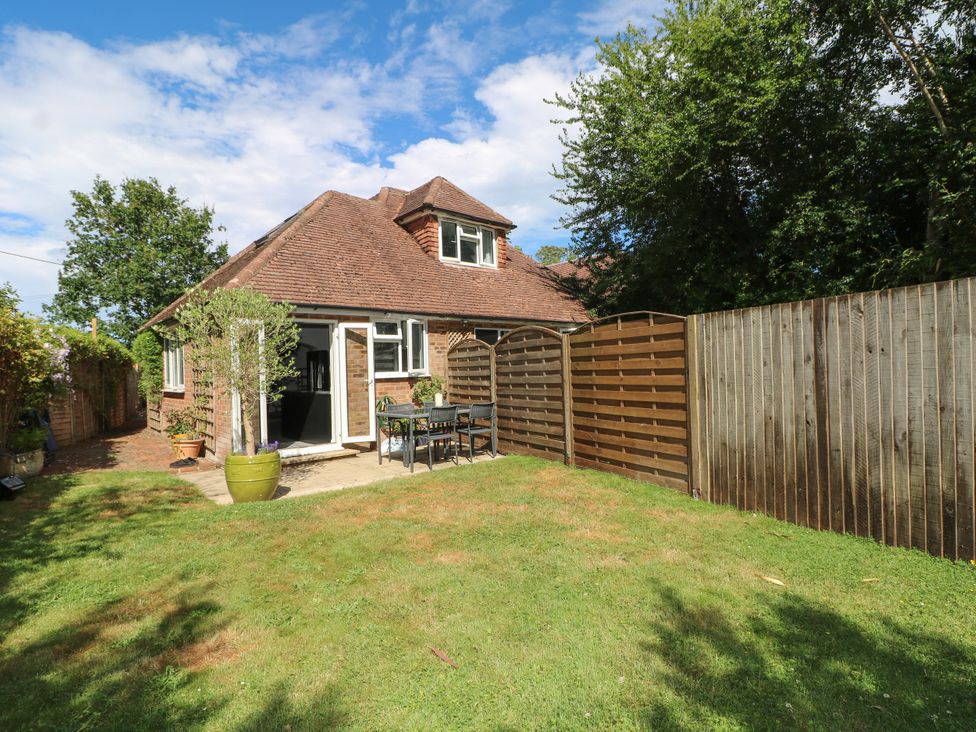 A garden with a table and chairs at Lucerne Cottage in Dorking