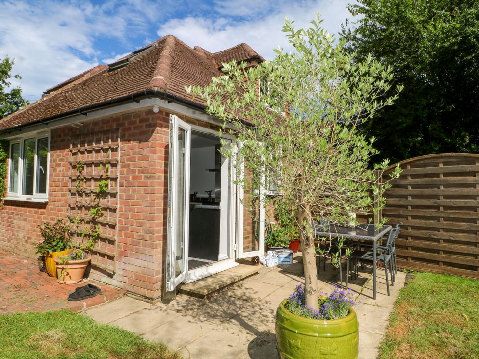 A garden area with a table and chairs at Lucerne Cottage in Dorking