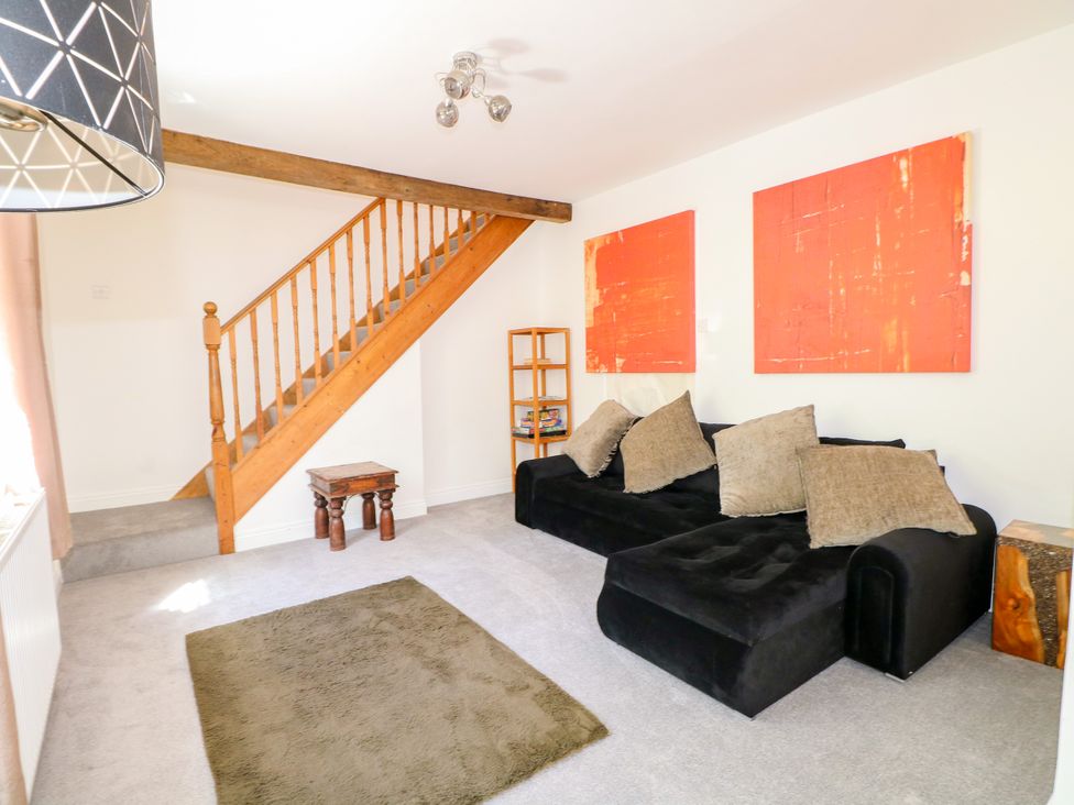 A living room with a sofa and staircase at Lucerne Cottage in Dorking