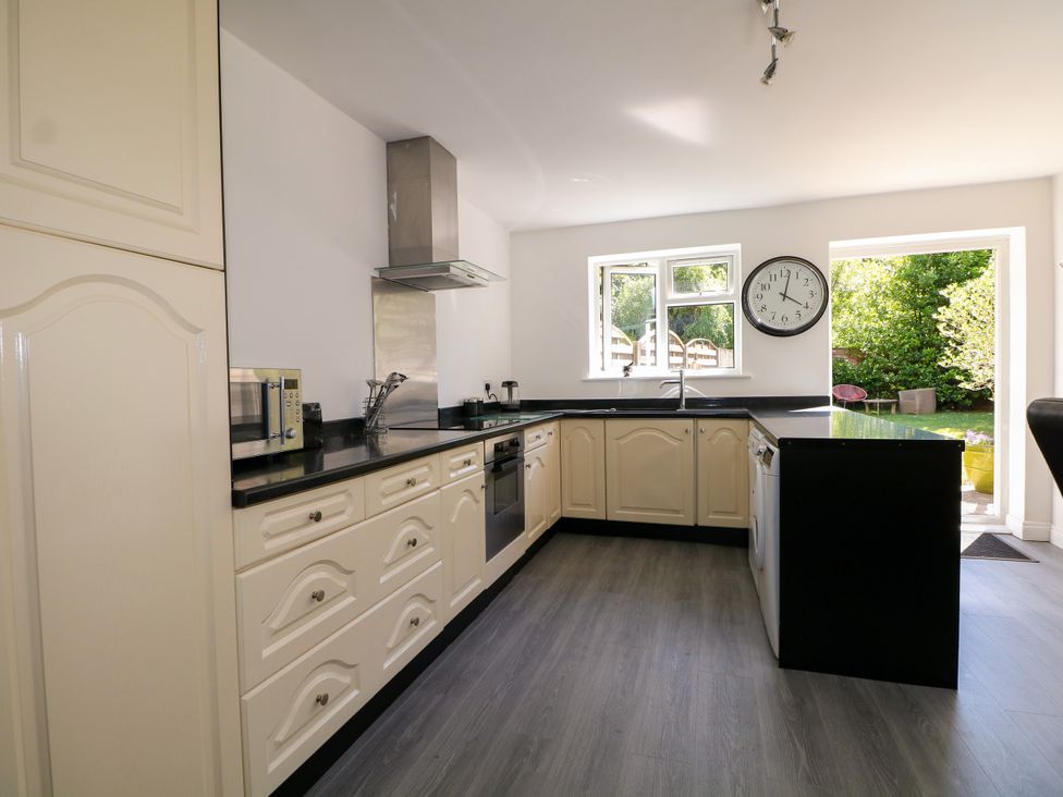 A kitchen with appliances and large window at Lucerne Cottage in Dorking