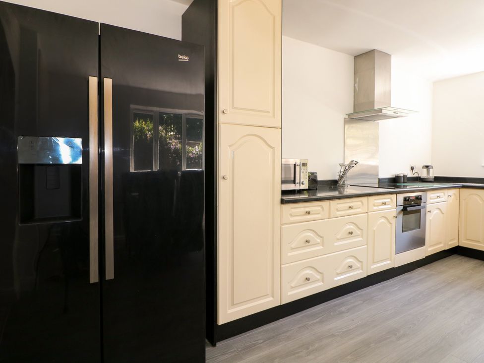 A kitchen with a refrigerator and microwave at Lucerne Cottage in Dorking
