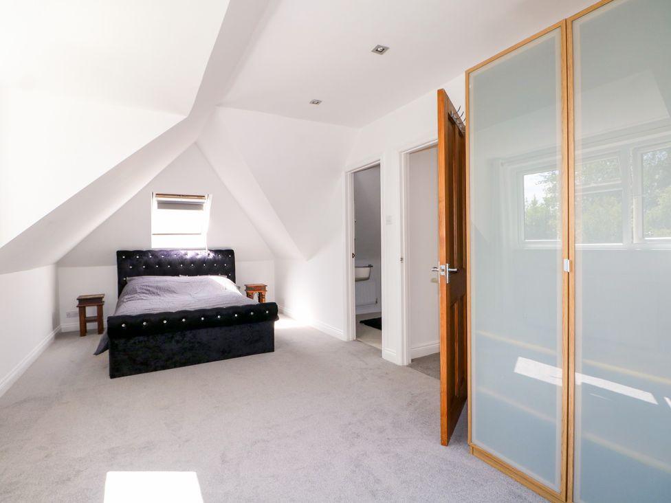 A bedroom with a bed and a bedside table at Lucerne Cottage in Dorking