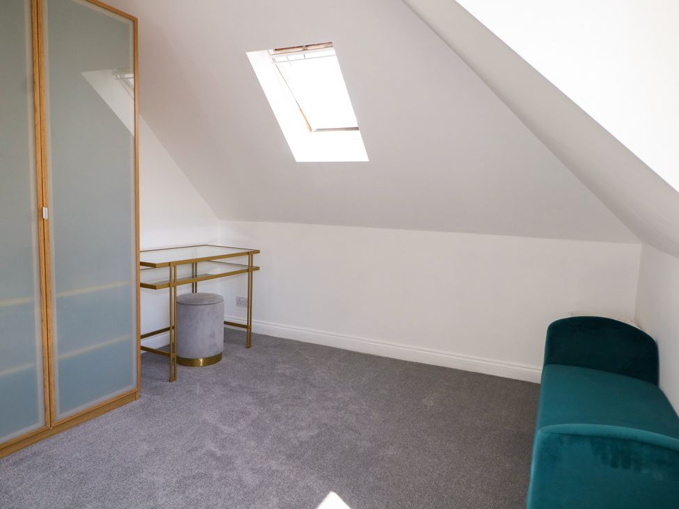 An attic room with a desk and stool at Lucerne Cottage in Dorking