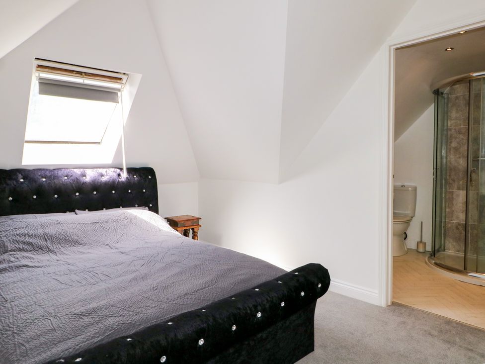 A bedroom with a bed and an attached bathroom at Lucerne Cottage in Dorking