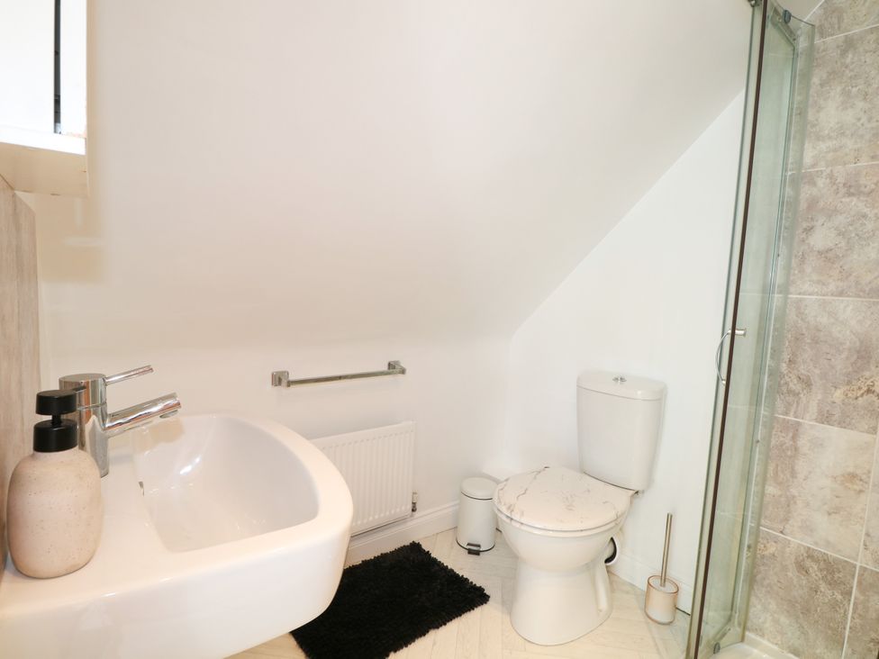 A bathroom with a sink, toilet, and shower at Lucerne Cottage Dorking