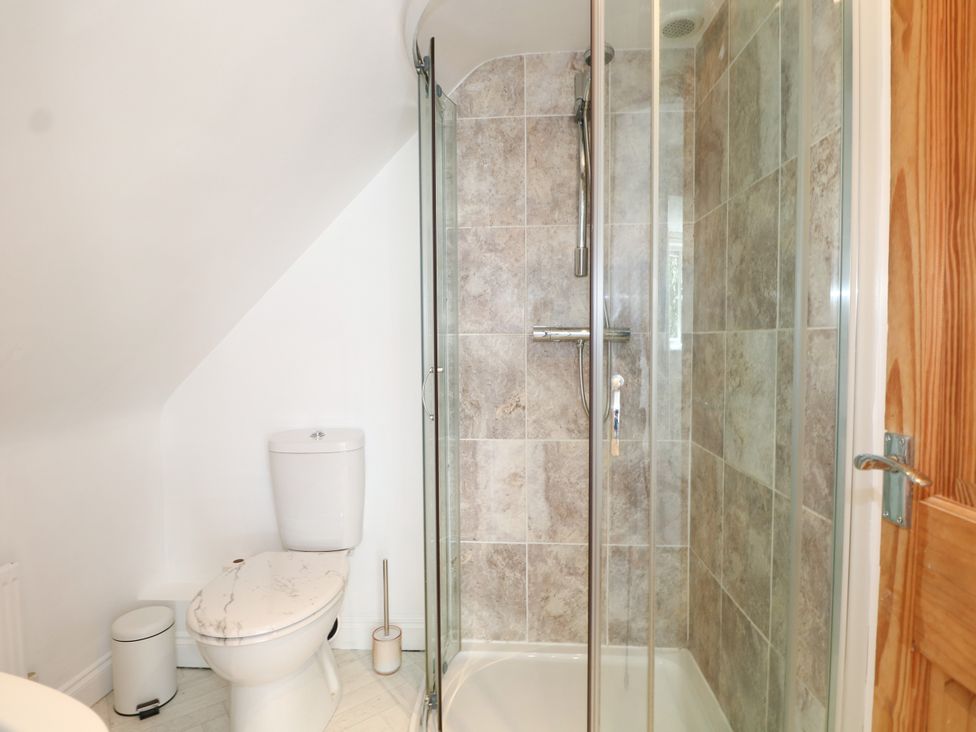 A bathroom featuring a shower and a toilet at Lucerne Cottage in Dorking