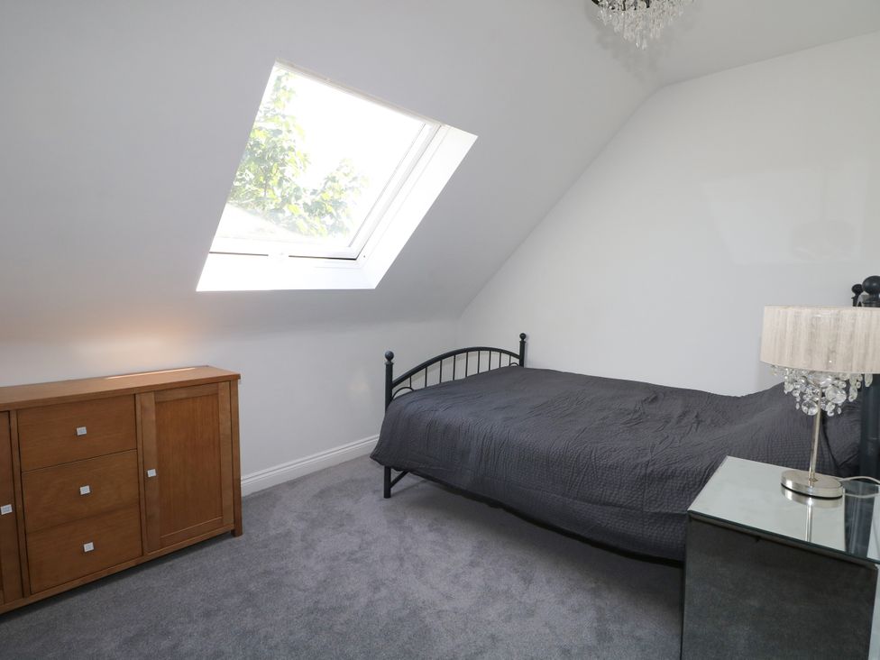 A bedroom with a bed and a chest of drawers at Lucerne Cottage in Dorking