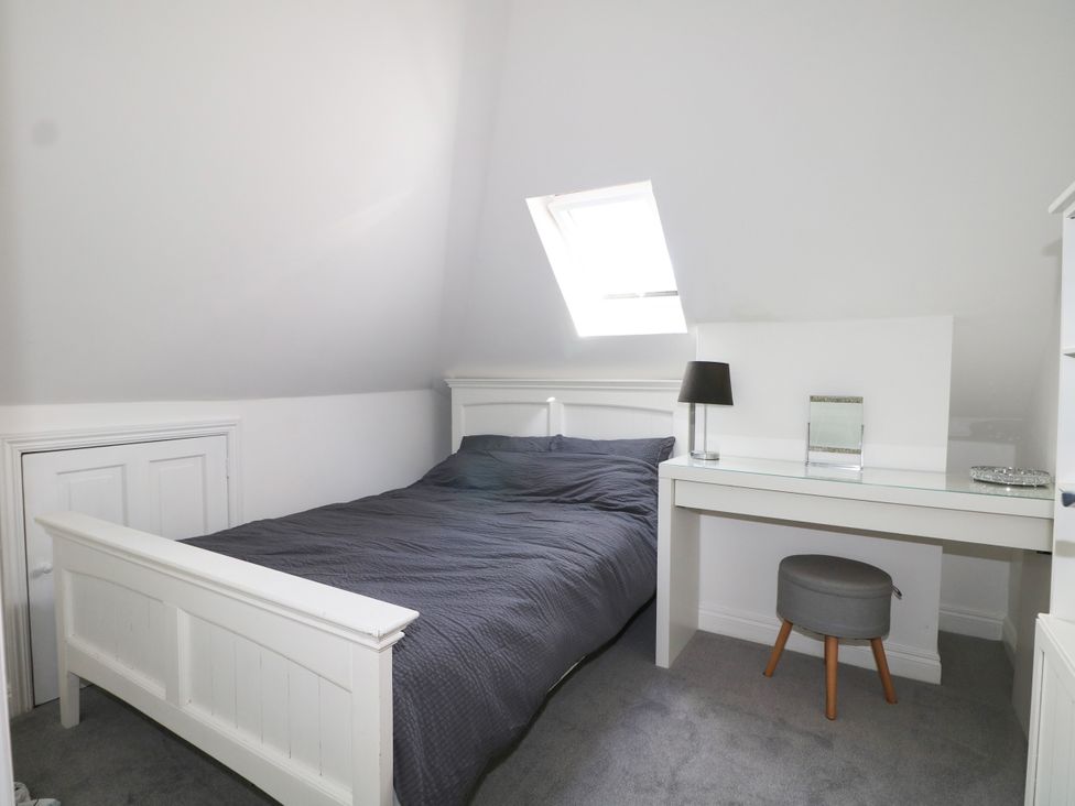 A bedroom with a bed and desk at Lucerne Cottage in Dorking