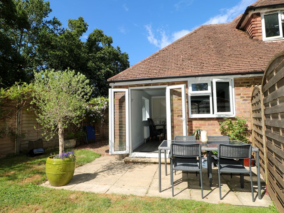 A garden area with a table and chairs at Lucerne Cottage in Dorking