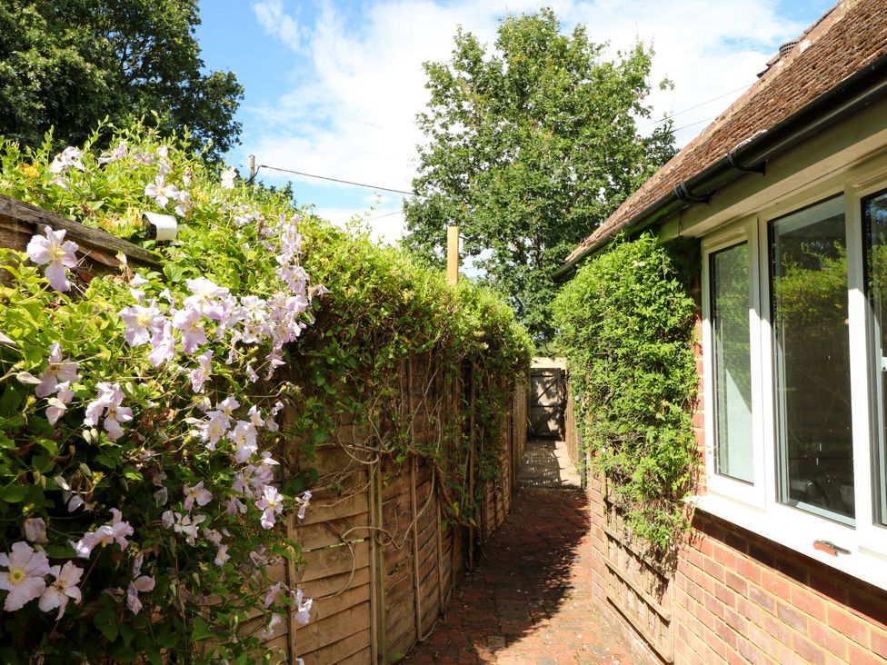 A garden path with flowers and fencing at Lucerne Cottage Dorking